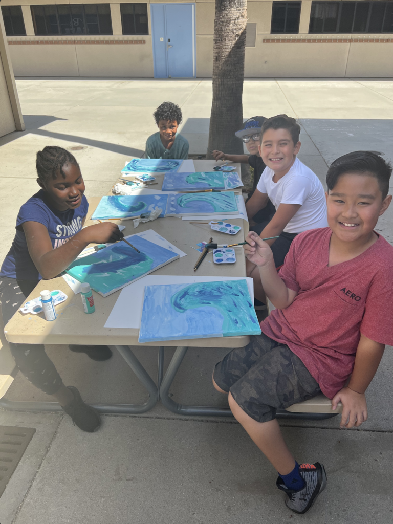 Students painting ocean waves.