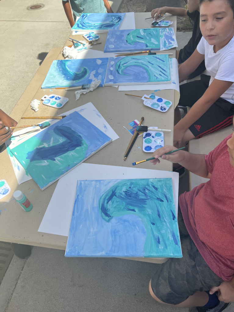 Students painting ocean waves.